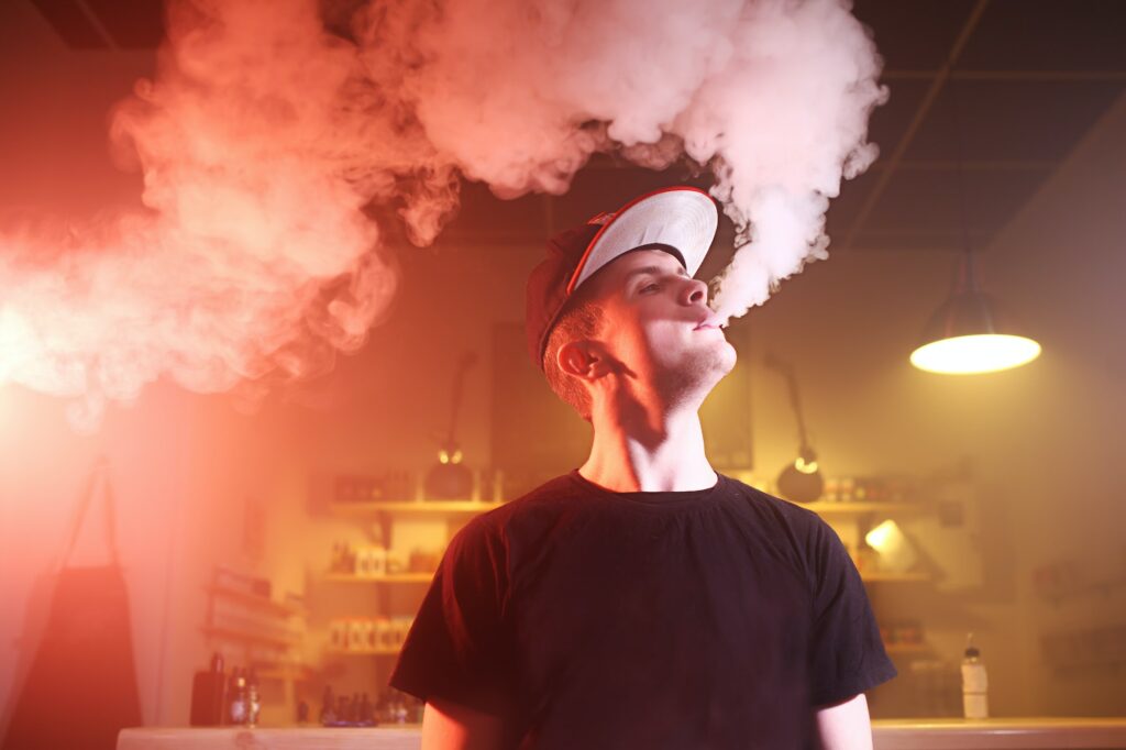 Vaping man in a cloud of vapor in a vape bar
